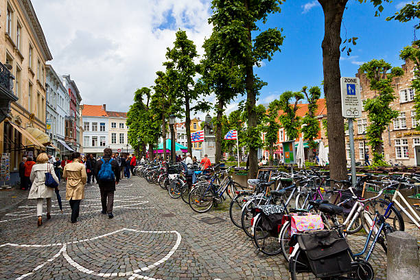 A bicycle rider and buildings on Botermarkt St. in Ghent, Belgium. Ghent is a medieval city and a municipality in the Flemish Region of Belgium.