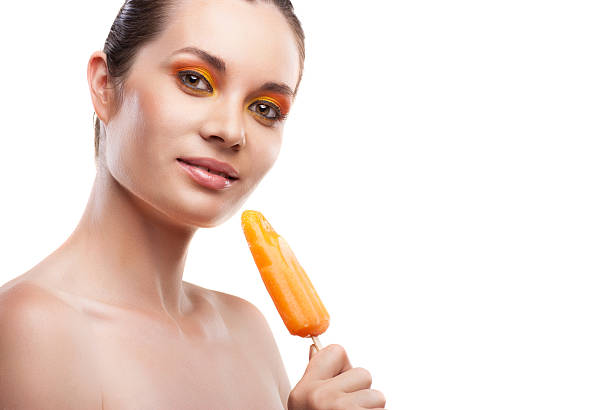 istock Woman eating orange ice-cream and having fun 471550755