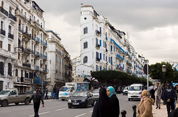 Algiers, Algeria - December 6, 2012: Avenue El Khettabi in Algiers with people walking along the street. This is one of the main shopping streets in the centre of Algiers and leads to the Grand Post Office in the centre of the city. The streets are lined with French colonial style buildings typical of this North African city.
