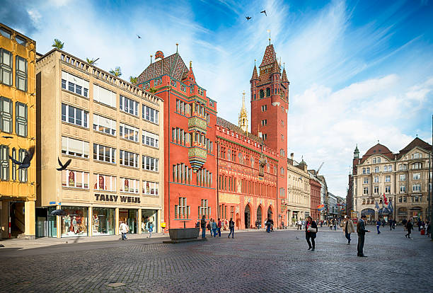 Basel, Switzerland - May 30, 2013: View at the Basel Town Hall and the Marktplatz in the center of Basel. It was erected between 1504 and 1514. It is the dominating building at the Marketplace in Basel. It is used for meetings of Cantonal Parliament and Cantonal Government Of Basel Stadt. On the Marketplace some pedestrians can be seen.