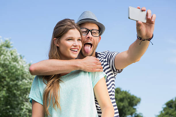 istock Cute couple in the park taking selfie 471552546