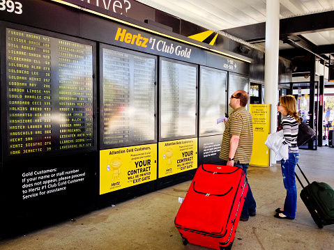 Los Angeles, USA - May 2, 2013: Hertz Customers looking at their names on schedule for Gold Club members, Los Angeles Airport, Hertz office rental.