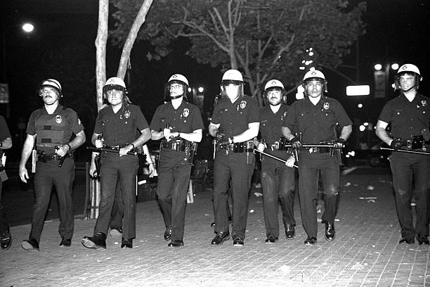 LAPD Advances Los Angeles, California - April 29, 1992: LAPD officers advance along Temple Street, downtown, during the first day of the Rodney King riots. riot photos stock pictures, royalty-free photos & images