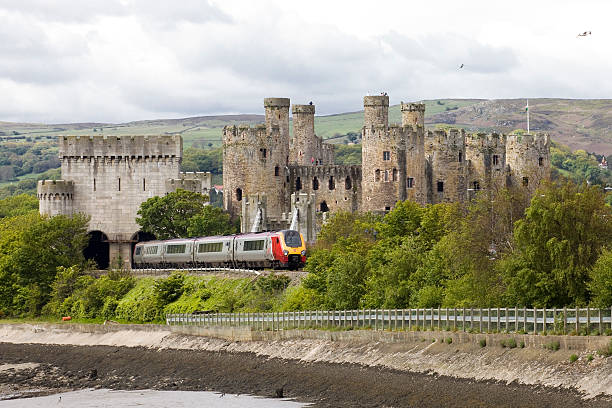 la virgen tren en la campiña pasa un castillo de gales - conwy castle train travel people traveling fotografías e imágenes de stock