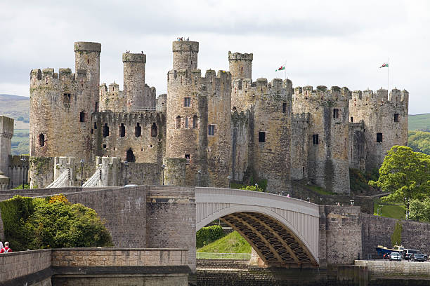 Fortified Towers of the Conwy Castle North Wales Conwy, Wales - June 2, 2013: Fortified Towers of the Conwy Castle North Wales. Conwy Castle, of the guard towers of the Conwy Castle North Wales. In the foreground is a road bridge with members of the public on it. People can be seen on the many towers of this impressive castle built to keep the Welsh under English rule. Conwy is a heavily fortified town with the castle at the heart protecting a valuable trade rout snowdonia national park photos stock pictures, royalty-free photos & images
