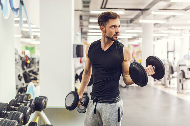 istock Young serious man having weight training at gym. 471559286