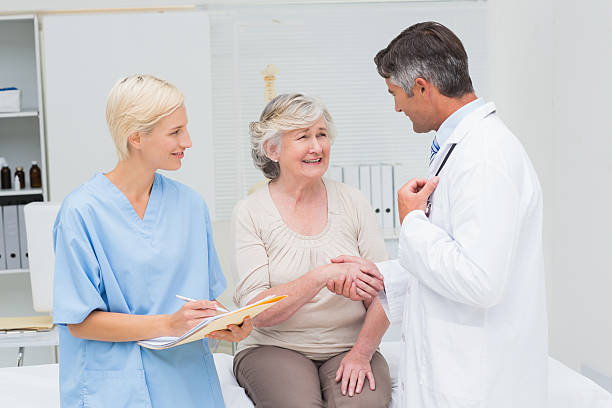 istock Doctor and patient shaking hands while nurse writing reports 471559318