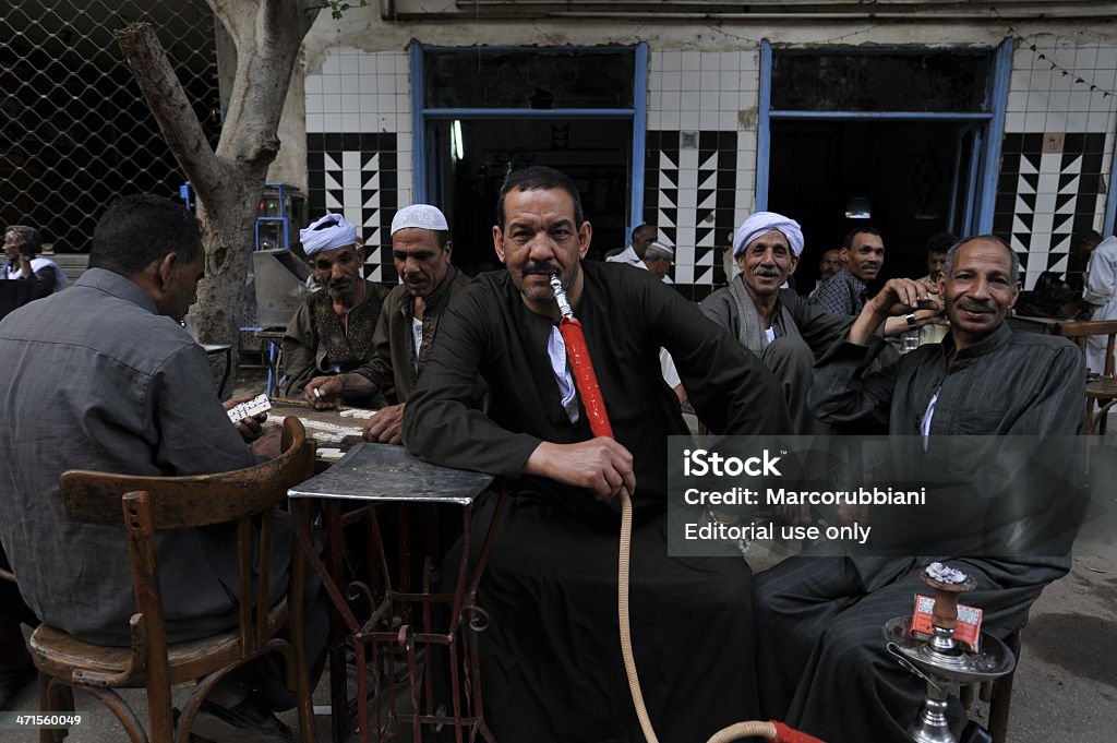 Uomo che fuma tubo dell'acqua in una caffetteria all'aperto del Cairo - Foto stock royalty-free di 2012