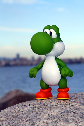 Vancouver, Canada - June 6, 2013: Yoshi from the Nintendo Super Mario franchise of games, posed against a natural background. The toy is from Banpresto Company.