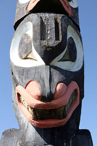 Predatory Face Sechelt, Canada - April 22, 2013: A totem pole on the waterfront of the Sechelt First Nation in Sechelt, British Columbia pacific northwest totem poles stock pictures, royalty-free photos & images