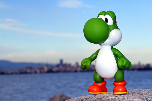 Vancouver, Canada - June 6, 2013: Yoshi from the Nintendo Super Mario franchise of games, posed against a natural background. The toy is from Banpresto Company.