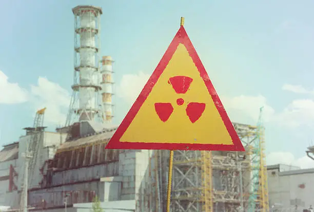 Vintage and grainy image of Radiation sign in front of "Chernobyl Nuclear Power Station", Ukraine