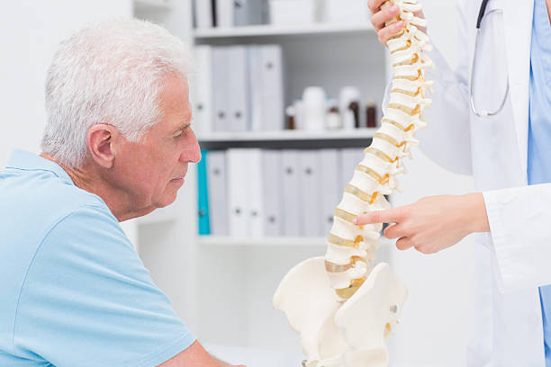 istock Doctor explaining anatomical spine to senior man 471561842