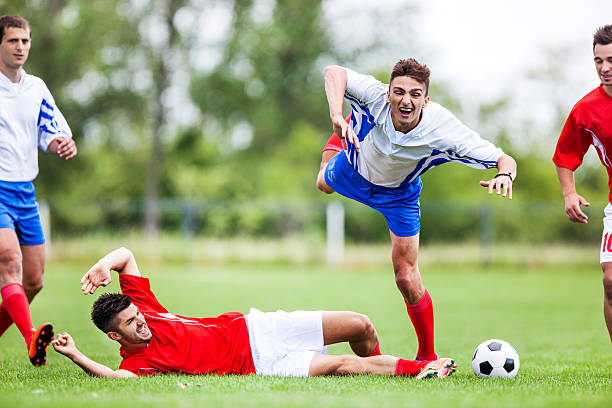 istock Soccer player jumping over tackling player during game. 471561858