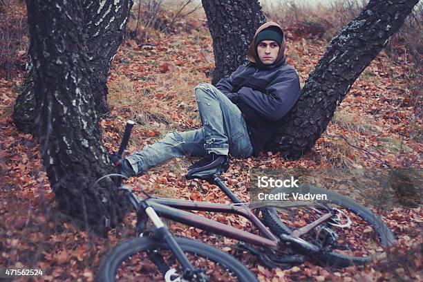 Pensive Cyclist Rests Under The Birch Tree With His Bicycle Stock Photo - Download Image Now