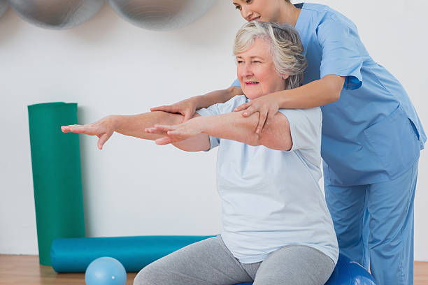 istock Instructor assisting senior woman to exercise 471562926