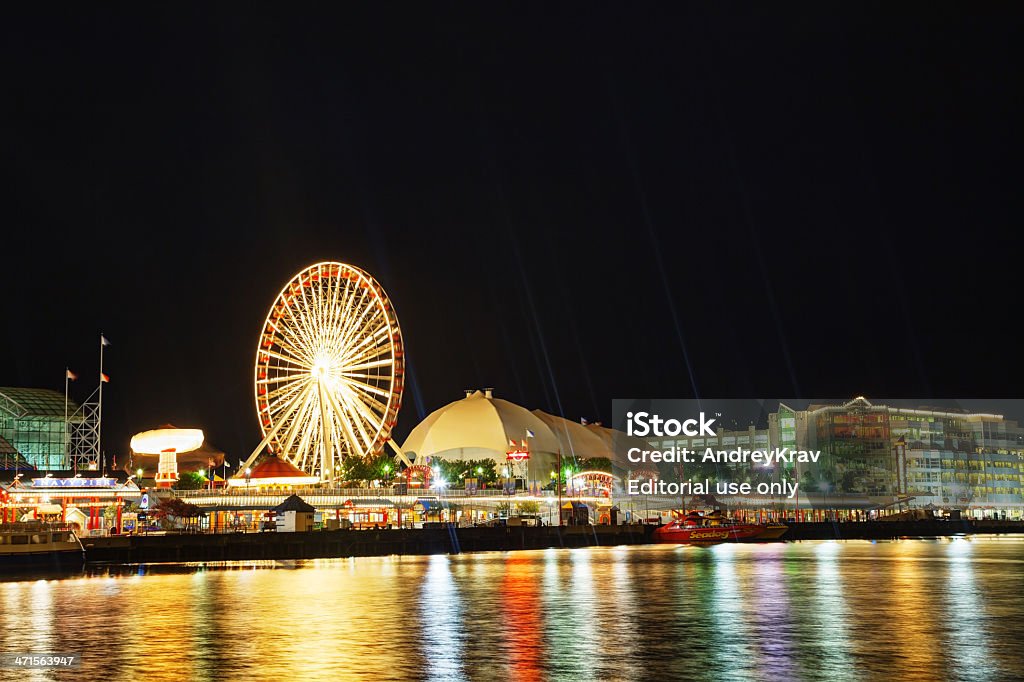 Navy Pier in Chicago at night time Chicago, USA - May 18, 2013: Navy Pier in Chicago, IL. It's is a 3,300-foot (1,010 m) long pier on the Chicago shoreline of Lake Michigan. Navy Pier is Chicago's number one tourist attraction. Architecture Stock Photo