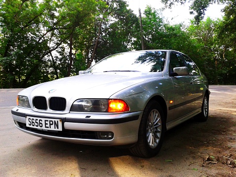 Moldova, Chisinau - June 09, 2013: A photo of a parked silver BMW 528i SE (E39) on the roadside. The BMW E39 is the BMW 5 Series made between 1995 and 2003. The E39 was the successor of the BMW E34 in 1995, and itself was replaced by the E60 in 2003.