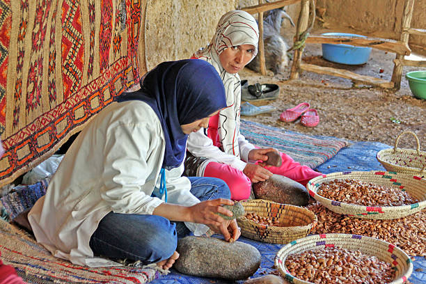 Women work in a cooperative for the manufacturing of argan Ourika valley, Morocco - May 28, 2012: Women work in a cooperative for the manufacturing of argan fruits berber stock pictures, royalty-free photos & images