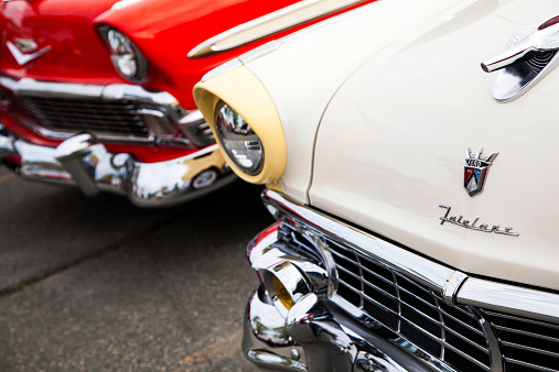 Dartmouth, Nova Scotia, Canada - June 6, 2013: A Ford Fairlane and Chevrolet Bel Air parked in a parking lot.  Vehicle closest is Fairlane showing hood mounted logo in clear focus.  Background car is Chevrolet Bel Air.