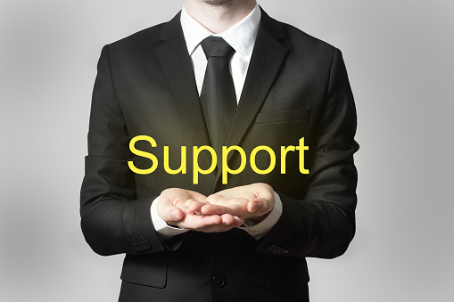businessman in office offering support hands open