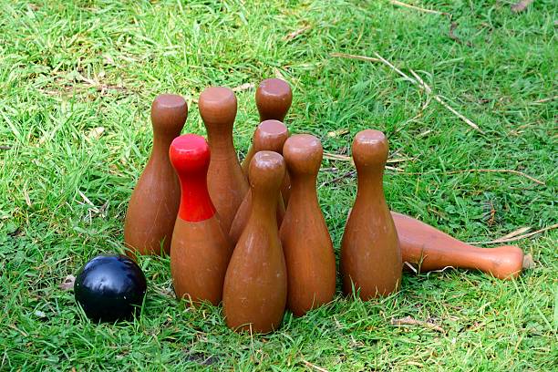 Throwing stick in finnish outdoors game Mölkky kubb\nFocus on hand and wooden stick with copy spcae