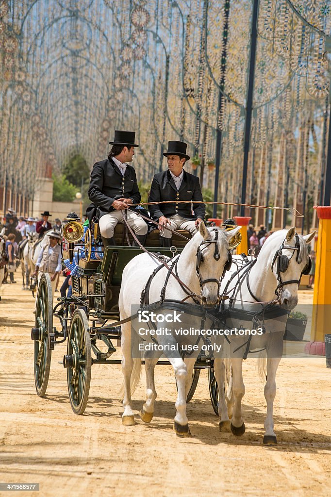 Horse Carriage at the Feria del Caballo, Jerez, Spain Jerez, Spain - May 10 , 2013 : Two men in traditional Andalucian costumes riding a horse and carriage at the Feria del Caballo in Jerez, Spain Adult Stock Photo