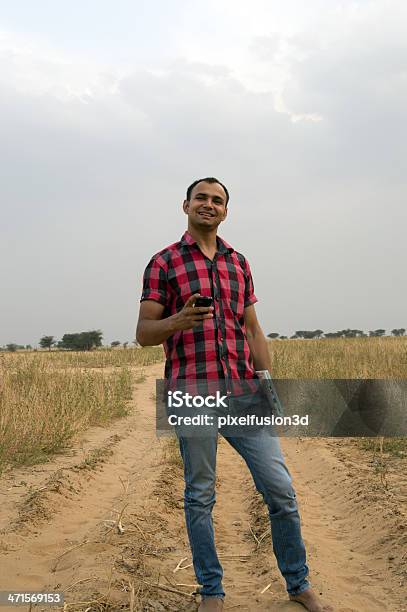 Man Standing In The Field Holding Laptop Stock Photo - Download Image Now - Activity, Adult, Adults Only