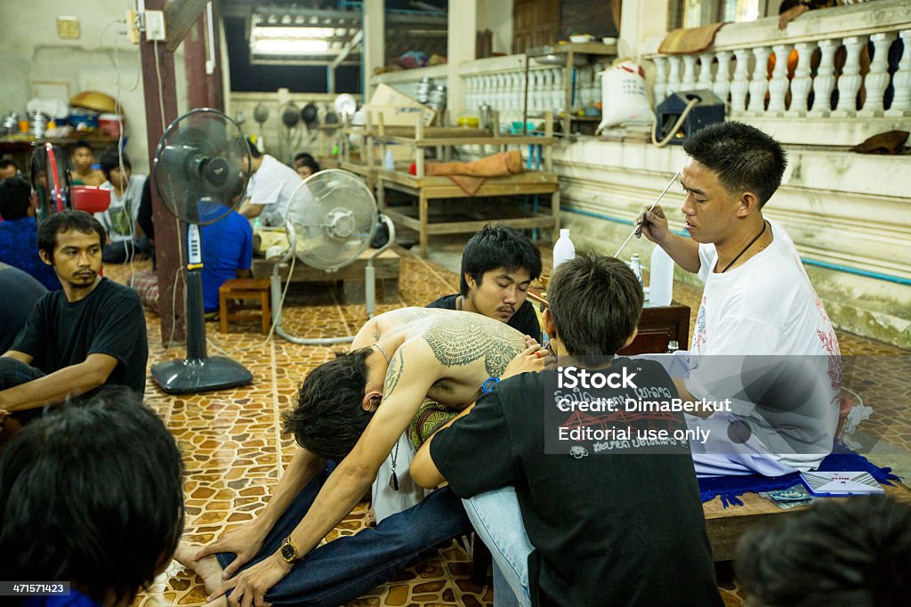 Master Day Ceremony in Wat Bang Pra monastery. Nakhon Chai, Thailand - March 23, 2013: Unidentified monk makes traditional Yantra tattooing during Wai Kroo Master Day Ceremony in Wat Bang Pra monastery. 2013 Stock Photo