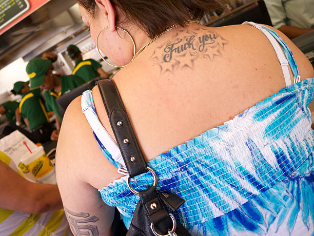 frau mit unfreundlich tattoo sich auf fast food restaurant - nathans coney island new york city brooklyn stock-fotos und bilder