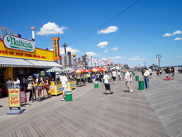 coney island boardwalk sommer szene new york city - nathans coney island new york city brooklyn stock-fotos und bilder