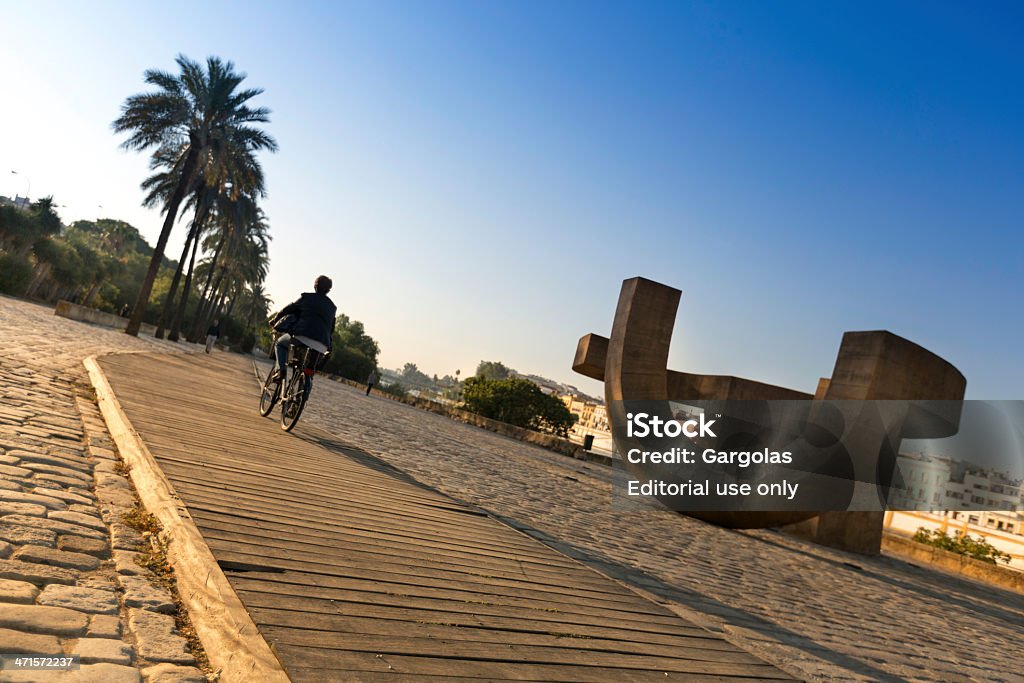 Motociclista próximo ao Monumento escultura em Sevilha, Espanha - Foto de stock de Ciclismo royalty-free