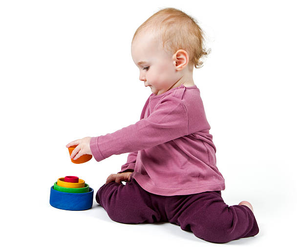 young child playing with colorful toy blocks stock photo