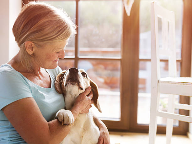 Senior woman petting her hound dog
