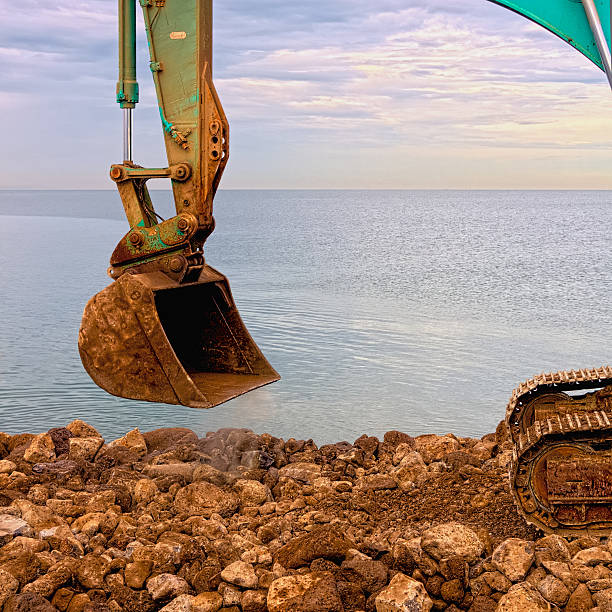 istock Excavating rocks by the sea 471578021