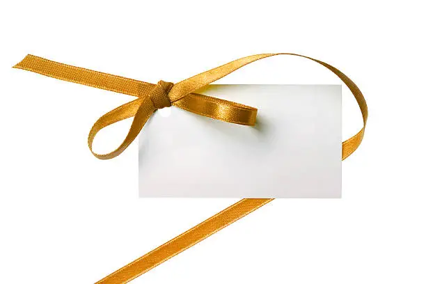 Photo of Blank gift tag tied with a bow of gold ribbon.