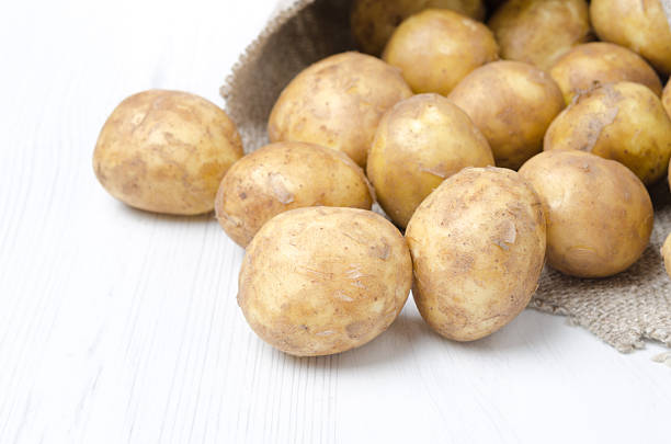 istock new potatoes in a sack on white background, selective focus 471580643