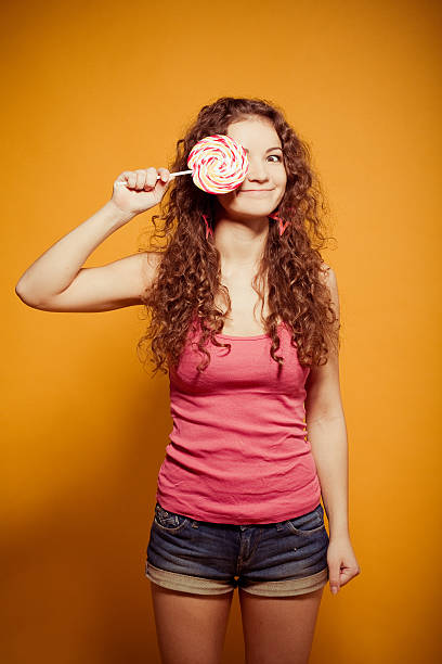 istock happy young woman with lollipop 471581117