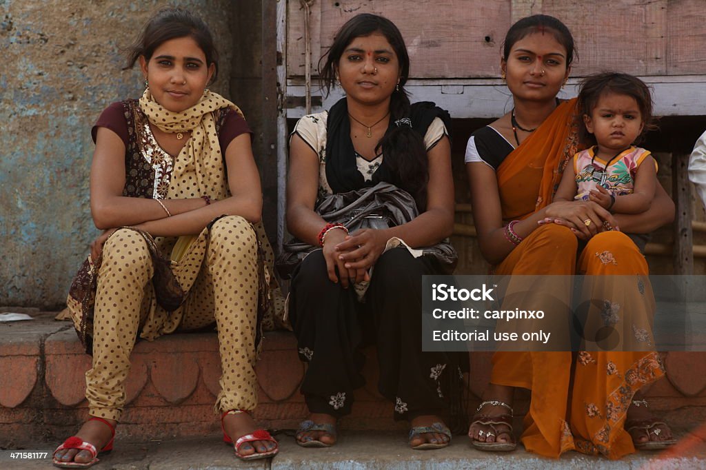 Young Indian girls Varanasi, India - March 30th, 2013 - 3 young Indian girls sitting in front of the camera at the Ganges shore in Varanasi. Adult Stock Photo