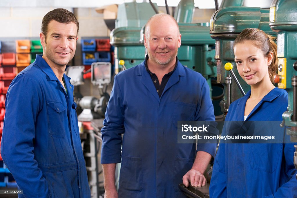 Drei machinists im Arbeitsbereich von Maschine sprechen - Lizenzfrei Industriearbeiter Stock-Foto