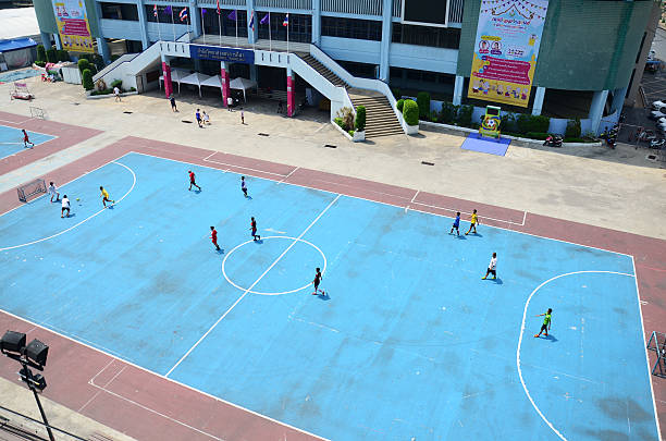 Bangkok, Thailand - April 5, 2015: Thai men playing football or soccer on field at front of sport stadium in Bangkok Thailand.