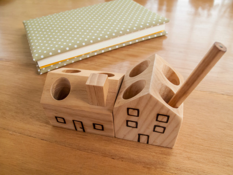 wood house pen holder and polka dot notebook.