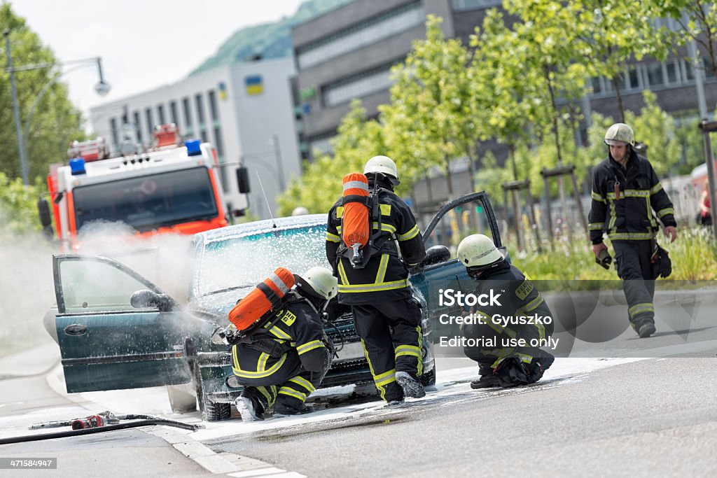 Burning Fahrzeug gestellt von Feuerwehrleuten in schützende Kleidung - Lizenzfrei Auto Stock-Foto