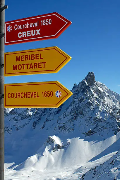 Direction Sign to Courchevel and Meribel in the skiresort Val Thorens, France with mountainrange in the background.