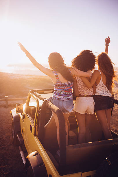 istock Friends watching the sunset together on a beach road trip 471587404