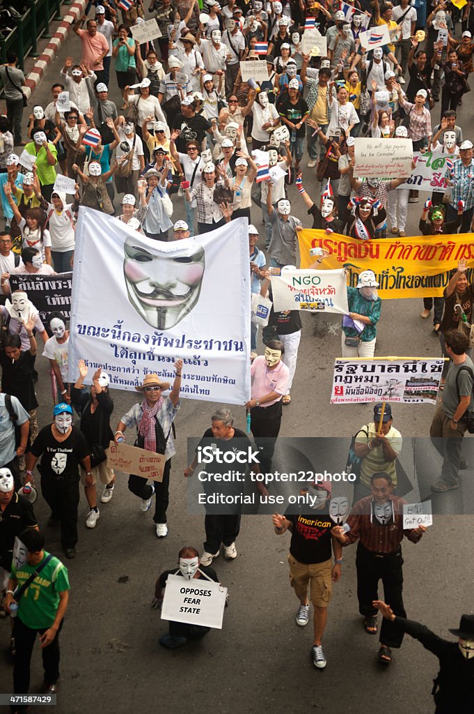 Demonstrators  from anti-government V for Thailand groups in Bangkok. Bangkok,Thailand-June 16,2013 : Unidentified demonstrators from the anti- government  V for Thailand group wearing  Guy Fawkes masks attend rally on public traffic road on June 16,2013 in Bangkok,Thailand. Adult Stock Photo