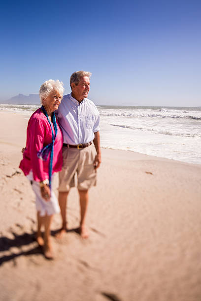 istock Senior retire couple standing on the beach together 471587514