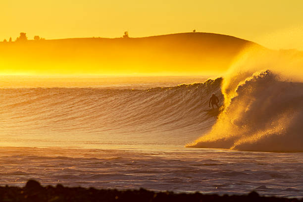istock Surfer surfing during a sunset with the wave crashing behind 471587559