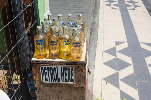 Kuta, Indonesia - September 25, 2014: Petrol station Balinese style where empty 1 litre vodka bottles are used as containers for petrol at roadside stands around the island