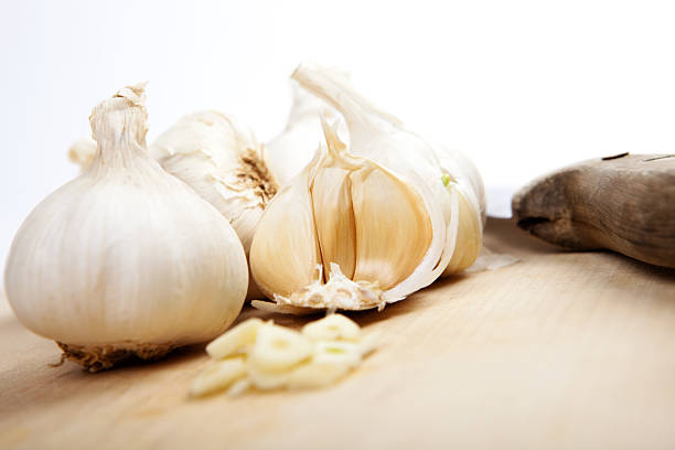 istock garlic on wooden board with knife, white background 471588352